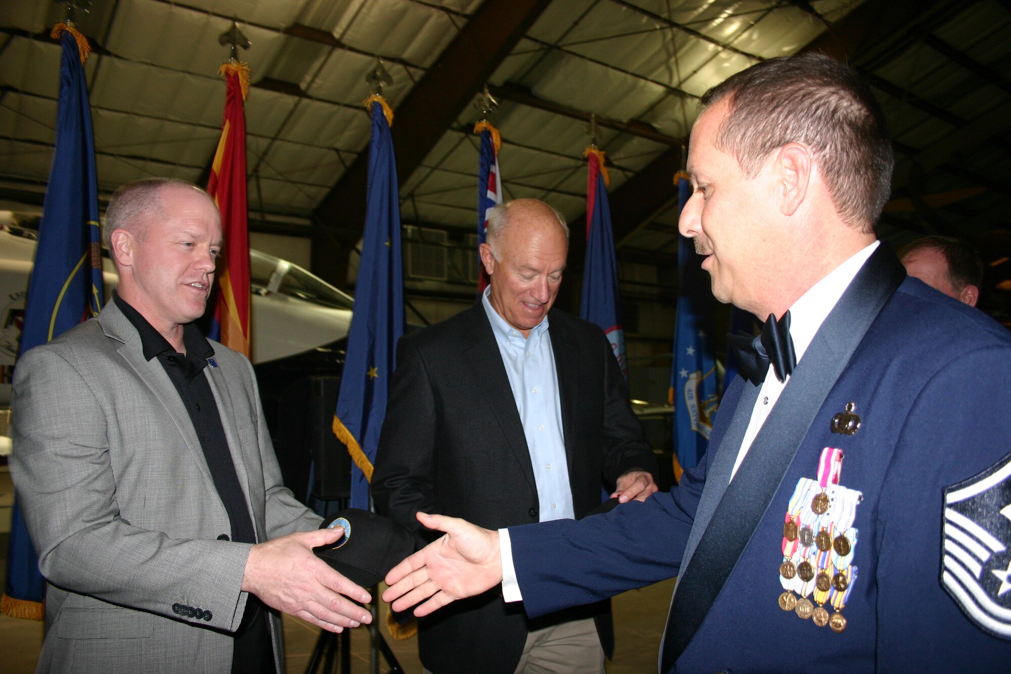 MSgt Scott McPherson presents Command Chief Muncy and Lt General Wyatt with Official 562nd Air Force Band hats and receives a hearty thanks in return for supporting the Air National Guard Business and Industry Days events in October 2010.