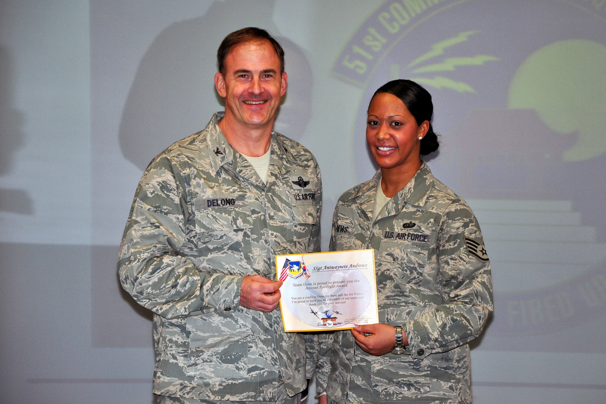 Col. Mark DeLong, 51st Fighter Wing Vice Commander, presents Staff Sgt. Antwaynete Andrews, 51st Communications Squadron, with a certificate for Airman Spotlight during a meeting Dec. 13, 2011. (U.S. Air Force photo/Tech. Sgt. Chad Thompson)