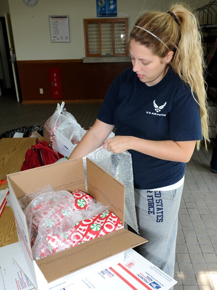 Brittney Jenkins, a U.S. Air Force dependant, packs a Christmas gift at the post office on Kadena Air Base, Japan, Nov. 22, 2011. Thousands of personnel pass through the Kadena post office during the holiday seasons to mail gifts back home. (U.S. Air Force photo by Junko Kinjo/Released) 