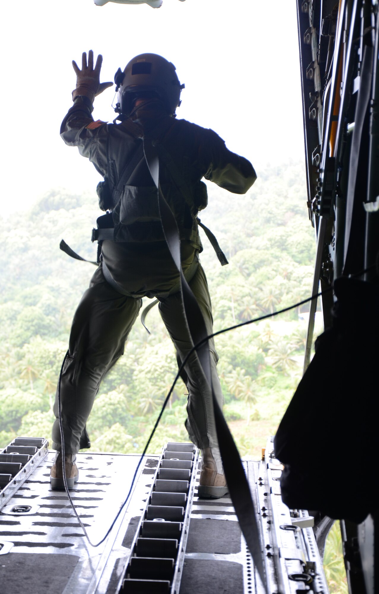 Over Fais Island, Micronesia - Master Sgt. Thomas Larson, 374th Airlift Wing loadmaster, waves to children on the ground after dropping a pallet full of medical supplies 300 feet to the island Fais to treat an outbreak of dengue fever.  The island of Fais is located within the Yap state of the Micronesian Islands, and is one of the more than 50 islands that will receive care packages this holiday season as part of Operation Christmas Drop.  (U.S. Air Force photo/Senior Airman Veronica McMahon)