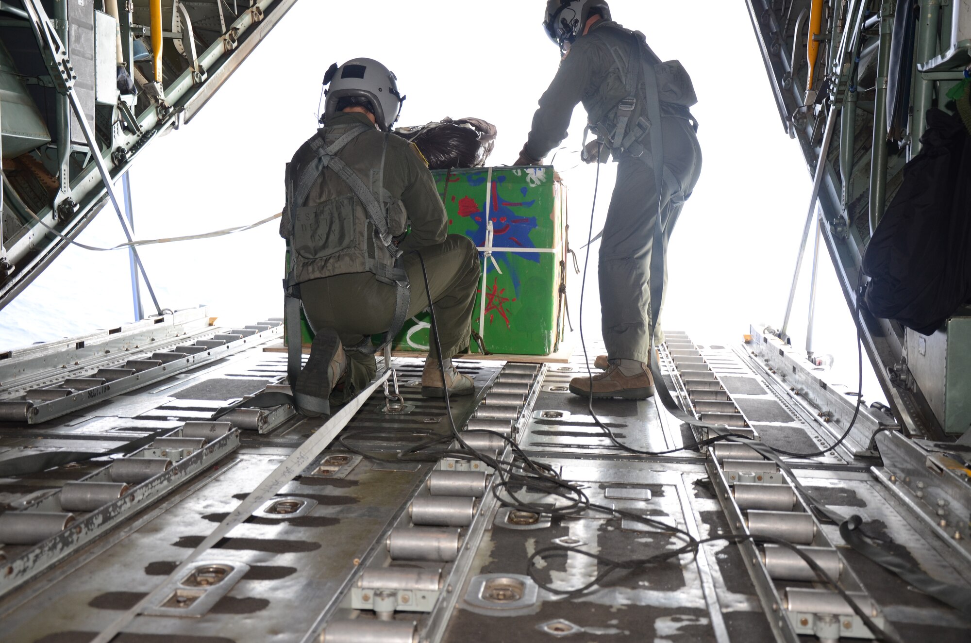 Over Fais Island, Micronesia - Staff Sgt. Kyle Favorite and Master Sgt. Thomas Larson, 374th Airlift Wing loadmasters, prepare to push a pallet of medical supplies to the island Fais to treat an outbreak of dengue fever.  The island of Fais is located within the Yap state of the Micronesian Islands, and is one of the more than 50 islands that will receive care packages this holiday season as part of Operation Christmas Drop.  (U.S. Air Force photo/Senior Airman Veronica McMahon)