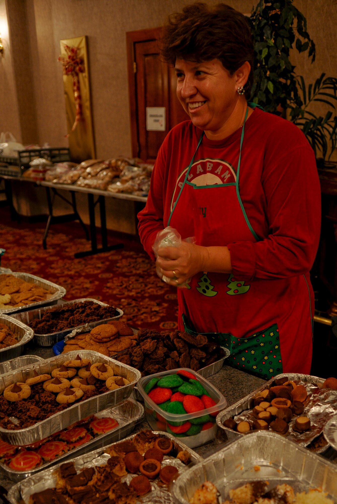 Katy Harvey, wife of Maj. Stephen Harvey, 18th Equipment Maintenance
Squadron commander, refills cookie bins for volunteers to use as they make bags full of cookies to be delivered to the single military members living in the dorms on Kadena Air Base, Japan, Dec. 13, 2011. A total of 2,500 Soldiers, Sailors, Marines and Airmen on Kadena, as well as 136 Sailors living on Camp Shields who work on Kadena, will benefit from the kindness Team Kadena has shown with cookies. (U.S. Air Force photo by Airman 1st Class Tara A. Williamson/Released)