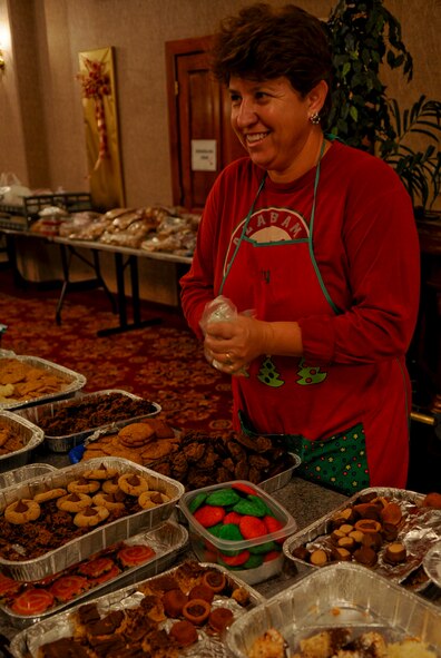 Katy Harvey, wife of Maj. Stephen Harvey, 18th Equipment Maintenance Squadron commander, refills cookie bins for volunteers to use as they make bags full of cookies to be delivered to the single military members living in the dorms on Kadena Air Base, Japan, Dec. 13, 2011. A total of 2,500 Soldiers, Sailors, Marines and Airmen on Kadena, as well as 136 Sailors living on Camp Shields who work on Kadena, will benefit from the kindness Team Kadena has shown with cookies. (U.S. Air Force photo/Airman 1st Class Tara A. Williamson/Released) 

