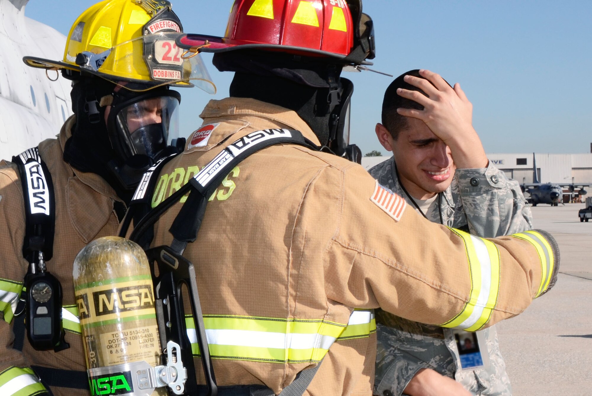 Airman Ricardo Hernandez from the 94th Maintenance Squadron posed as an injured maintenance person and is assisted by Dobbins Fire and Rescue Services during a mass casualty exercise held here Dec. 13. (U.S. Air Force photo/Don Peek)