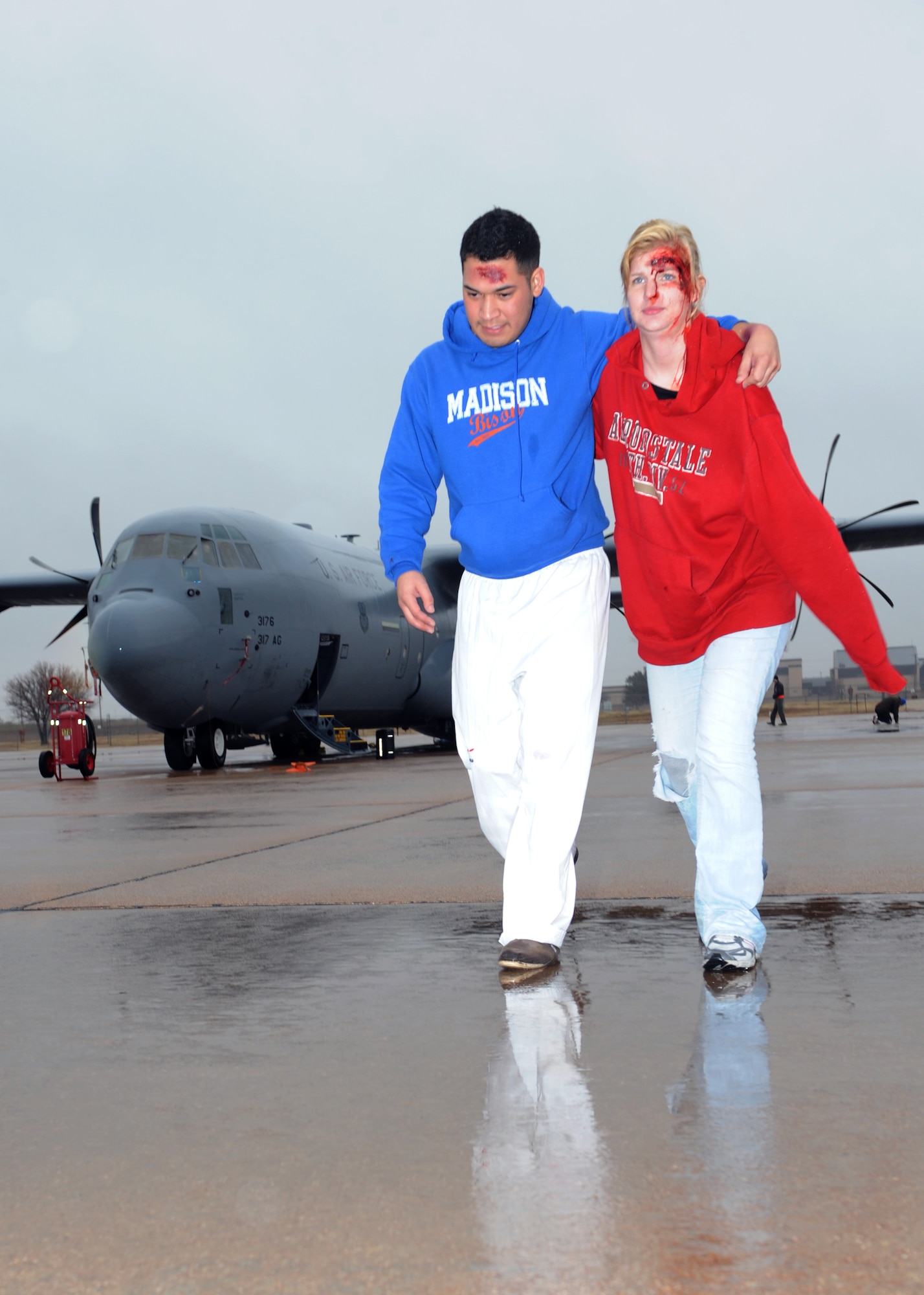Airmen playing as moulages walk away from a C-130 during an Emergency Management Exercise Dec. 13, 2011, at Dyess Air Force Base, Texas. The exercise tested response time to a terrorist hijacking scenario and consisted of more than 200 Dyess members. Exercises vary in scenarios and are conducted every two months keeping airmen prepared for real world situations. (U.S. Air Force photo by Airman 1st Class Jonathan Stefanko/ Released)