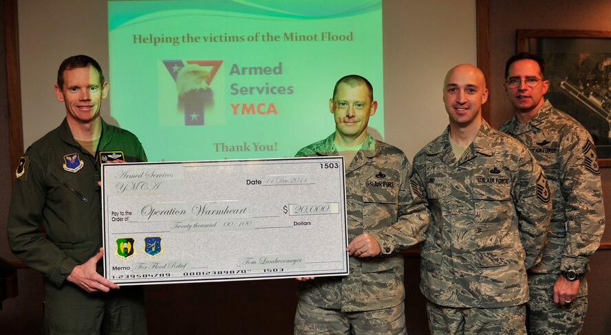 MINOT AIR FORCE BASE, N.D. -- Base leadership presented Team Minot’s Operation Warmheart with a charitable donation of $20,000 on behalf of the Armed Services YMCA Dec. 14. Funds from donations are used to help Airmen and their families with grants to help offset flood-related expenses. (U.S. Air Force photo/Senior Airman Desiree Esposito)