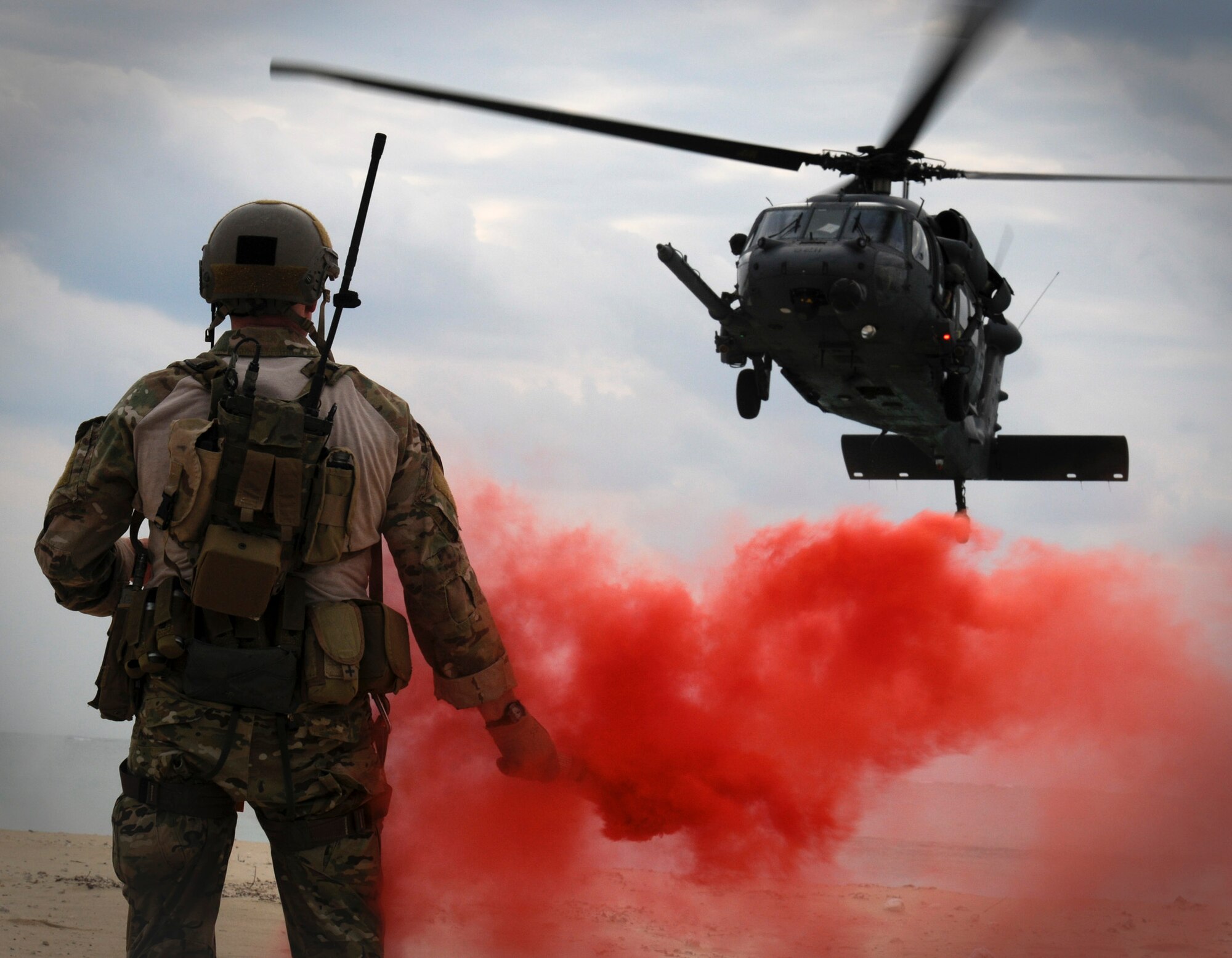 Maj. Matthew McGuinness pops a flare to signal an HH-60G Pave Hawk where to land during Exercise Cope Angel 12 Dec. 5, 2011, in Okinawa, Japan. The 33rd and 31st Rescue Squadrons paired up with partners from the Japan Air Self-Defense Force during Cope Angel to train on water and land rescue and triage tactics. McGuiness is the 31st Rescue Squadron director of operations. (U.S. Air Force photo/Airman 1st Class Maeson L. Elleman)
