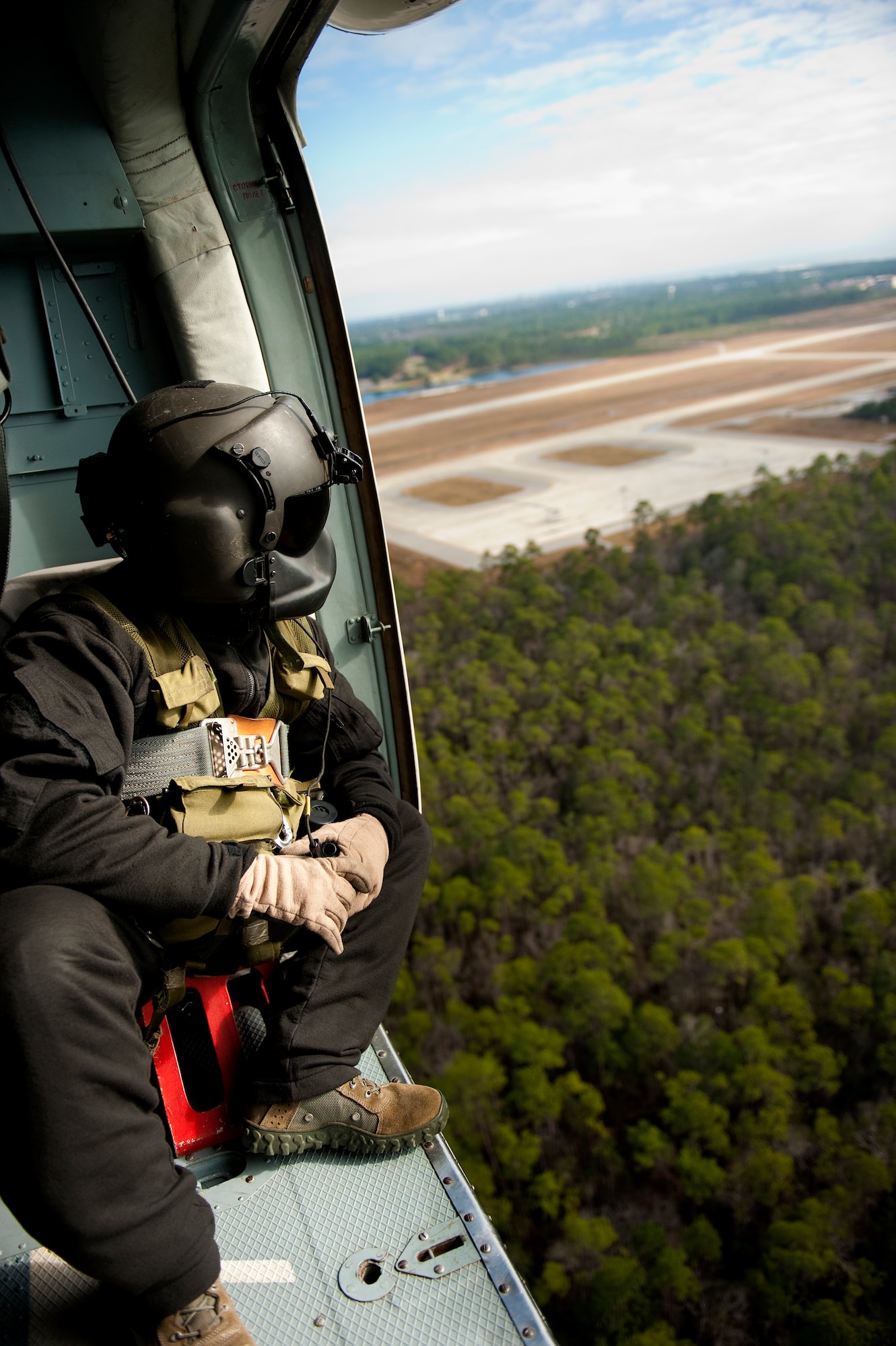 U.S. Air Force Tech. Sgt. Brian Hill, aerial gunner instructor for the 6th Special Operations Squadron, scans the woods during an honorary commander flight on an Mi-17 Hip over Hurlburt Field, Fla., Dec. 13, 2011. The honorary commanders take part in demonstrations on Hurlburt Field once every quarter. (U.S. Air Force photo/Airman 1st Class Christopher Williams)(Released)