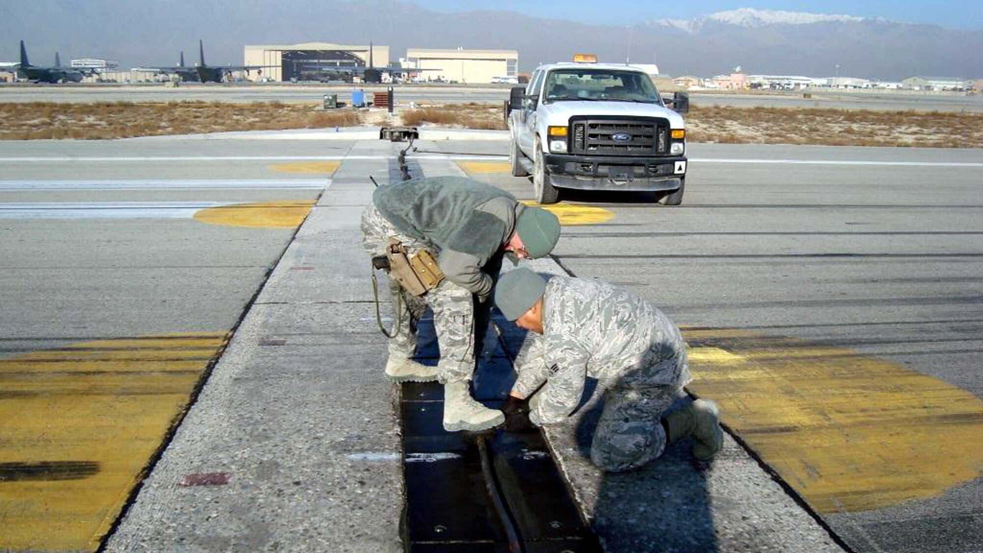 TRAVIS AIR FORCE BASE, Calif.  -- 349th Mission Support Squadron commander, Lt. Col. Neal Landeen working at cutting off the donuts on runway, 10 Dec, while he visits with the Expeditionary Civil Engineer Squadron folks at Bagram Airfield, Afghanistan. (U.S. Air Force courtesy photos)