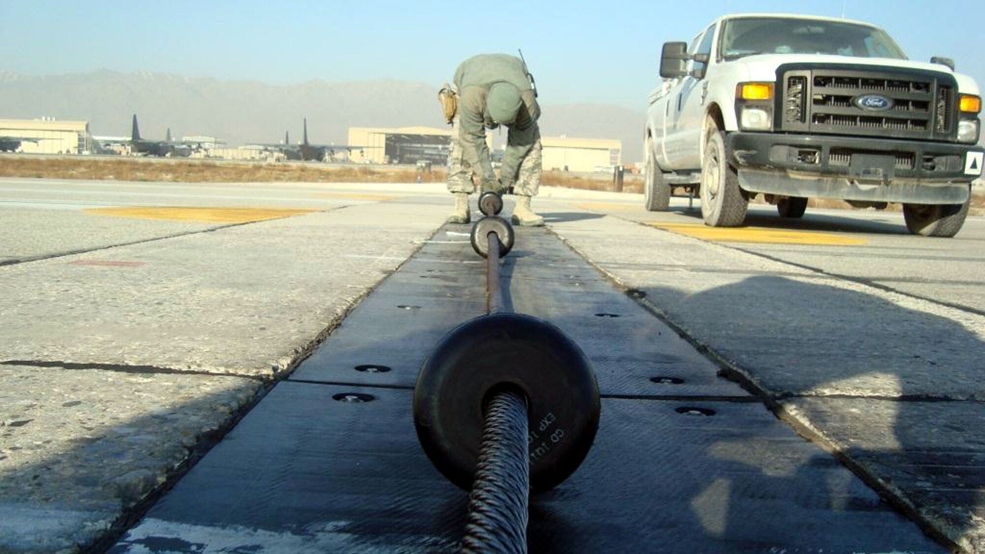 TRAVIS AIR FORCE BASE, Calif.  -- 349th Mission Support Squadron commander, Lt. Col. Neal Landeen working at spacing the donuts on runway, 10 Dec, while he visits with the Expeditionary Civil Engineer Squadron folks at Bagram Airfield, Afghanistan. (U.S. Air Force courtesy photos)