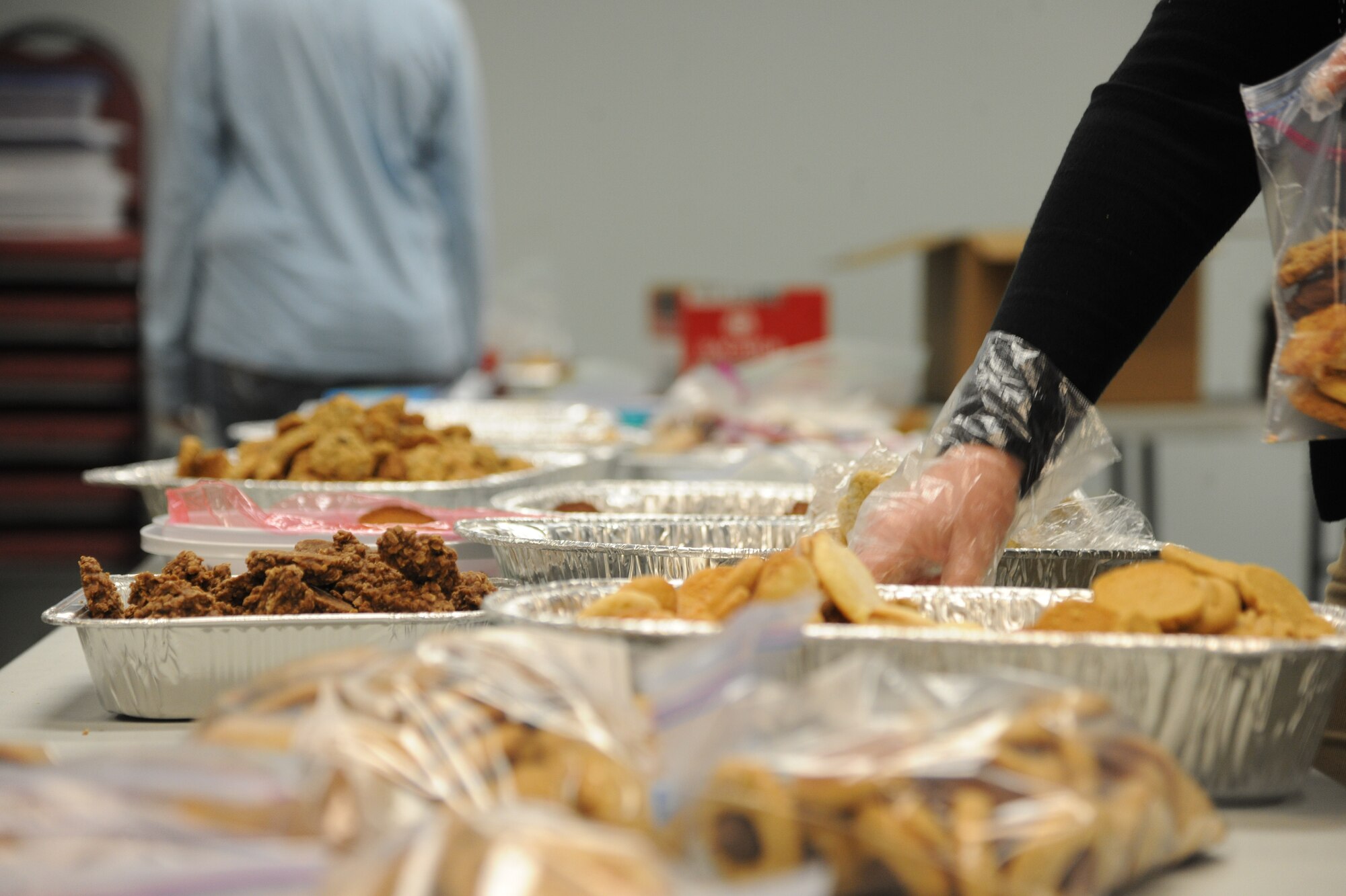Members of Moody Air Force Base, Ga., volunteer to give Moody Airmen a little taste of home for the holidays by holding a cookie drive Dec. 13, 2011. Cookies were dropped off at the Base Chapel, where they were sorted, bagged and distributed to Airmen living in the dorms and downrange. (U.S. Air Force photo by Airman 1st Class Paul Francis/Released)
