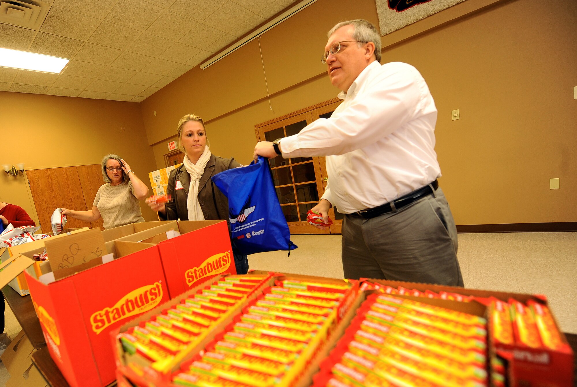 Fred Simon, from Pilgrim Lutheran Church, along with Jamie Menichetti, from Great Western Bank, assemble gift bags to be given to Airman in the Offutt Air Force Base dormitories, Dec. 13 in Bellevue, Neb. More than 650 bags were filled with treats for the Airman