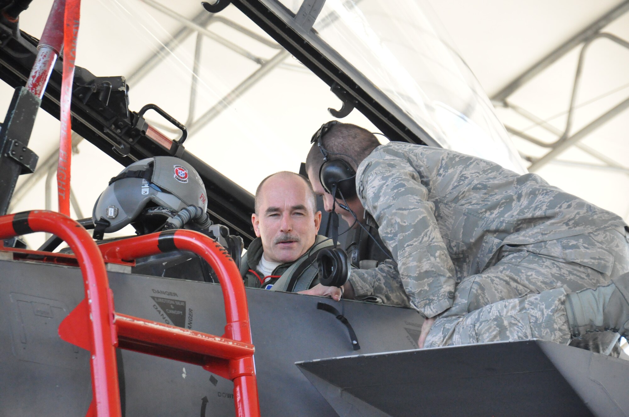 Col. Bruce Edwards, Air Combat Command chief flight surgeon, talks with Airman 1st Class Jason Edwards, 4th Aircraft Maintanence Squadron crew chief before taxing to the runway at Seymour Johnson Air Force Base, N.C., Dec. 8, 2011. Col. Edwards and Jason have flown together in their own jet before, but this will be the first time Jason will marshall his father out in an F-15E Strike Eagle. The colonel is stationed at Langley Air Force Base, N.C., and hails from Flagstaff Ariz. and Jason is stationed here and is a native of Hampton Roads,Va. (U.S. Air Force photo by Airman 1st Class Mariah Tolbert)