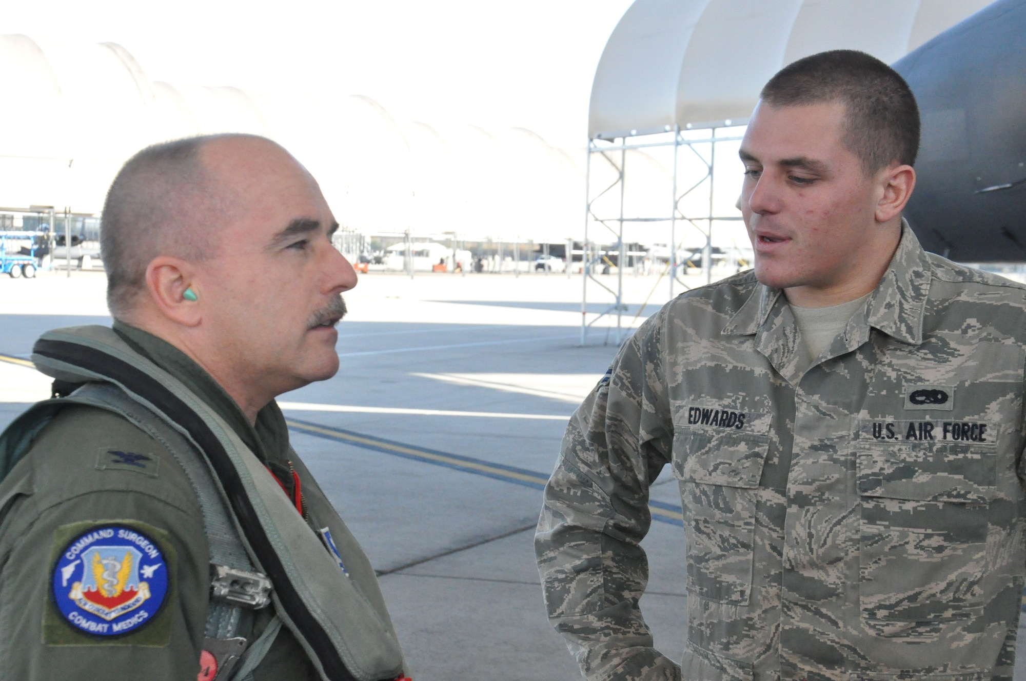 Col. Bruce Edwards, Air Combat Command chief flight surgeon stationed at Langley Air Force Base, Va., and his son, Airman 1st Class Jason Edwards, 4th Aircraft Maintanence Squadron crew chief, talk before inspecting the aircraft on Seymour Johnson Air Force Base, N.C., Dec. 8, 2011. Jason marshalled his father off the runway in an F-15E Strike Eagle for the first time. Col. Edwards is stationed at Langley Air Force Base, N.C., and hails from Flagstaff Ariz. and Jason is stationed here and is a native of Hampton Roads,Va. (U.S. Air Force photo by Airman 1st Class Mariah Tolbert)