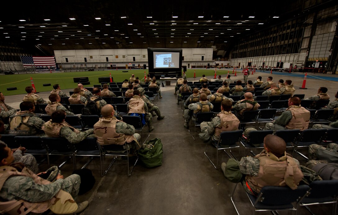 Airmen of the 28th Bomb Wing watch deployment briefing videos in the Pride Hangar during an Operational Readiness Exercise on Ellsworth Air Force Base, S.D., Dec. 7, 2011. Videos from various facilities gave Airmen informative instructions for a quick and safe deployment. (U.S. Air Force photo by Airman 1st Class Kate Thornton/Released)