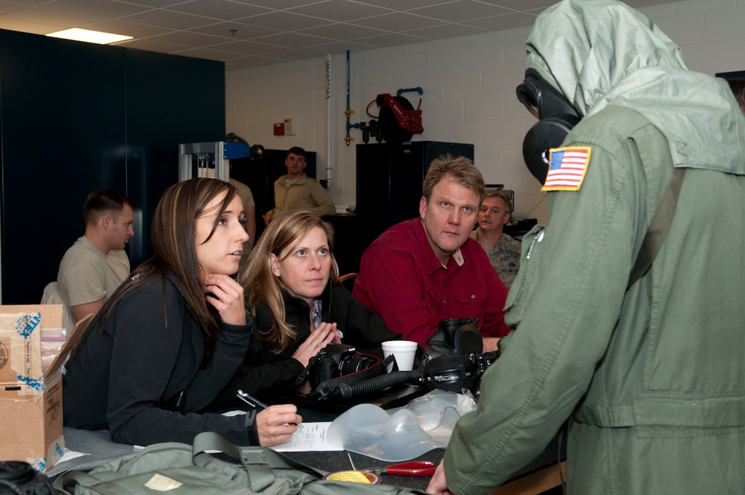 Erin Kennedy, Nicole Fletcher, and Wayne Shira, Joint Service Aircrew Mask - Fixed Wing (JSAM-FW) research team members, listen to feedback from Staff Sgt. Alex Whalton, 167th Airlift Squadron flight engineer, as he wears the M-53 mask and hood, part of the JSAM-FW system. A Department of Defense research team working on the development of aJSAM conducted field assessments at the 167th Airlift Wing, West Virginia Air National Guard unit in Martinsburg, WV,  December 7, 2011. The team had aircrew in each of the flying positions don the mask and accompanying gear and perform their duties on a C-5 aircraft. (Air National Guard photo by Master Sgt. Emily Beightol-Deyerle)