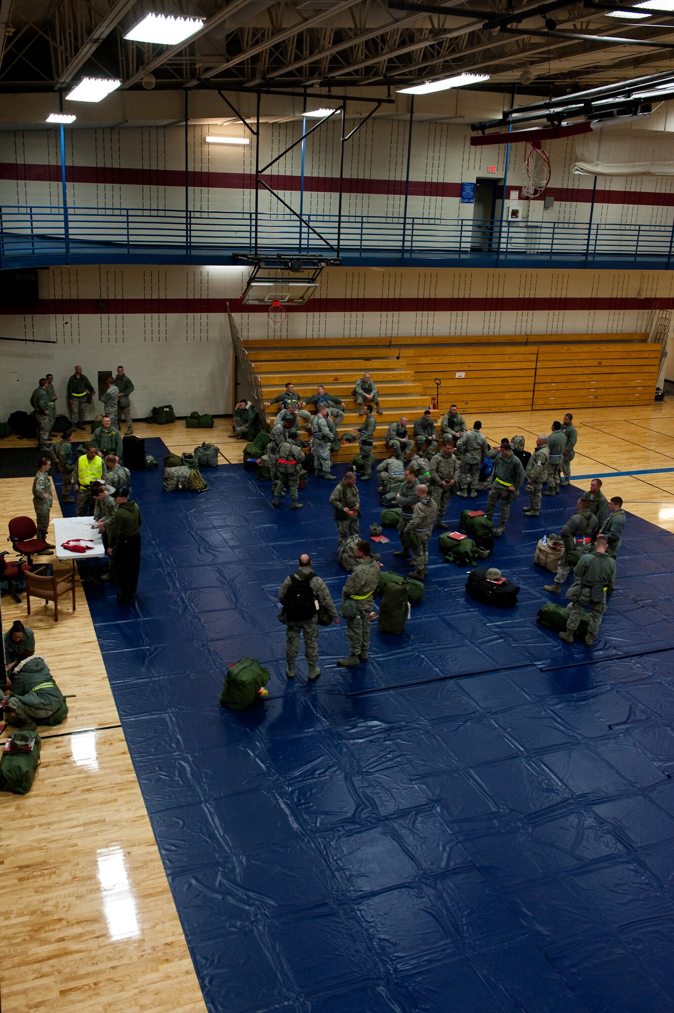 Ellsworth Airmen meet in the Bellamy Fitness Center to begin the deployment processing portion of an Operational Readiness Exercise on Ellsworth Air Force Base, S.D., Dec. 6, 2011. Airmen gathered and awaited transportation to the Pride Hangar where they were quickly out-processed for the simulated mass deployment. (U.S. Air Force photo by Airman 1st Class Kate Thornton/Released)
