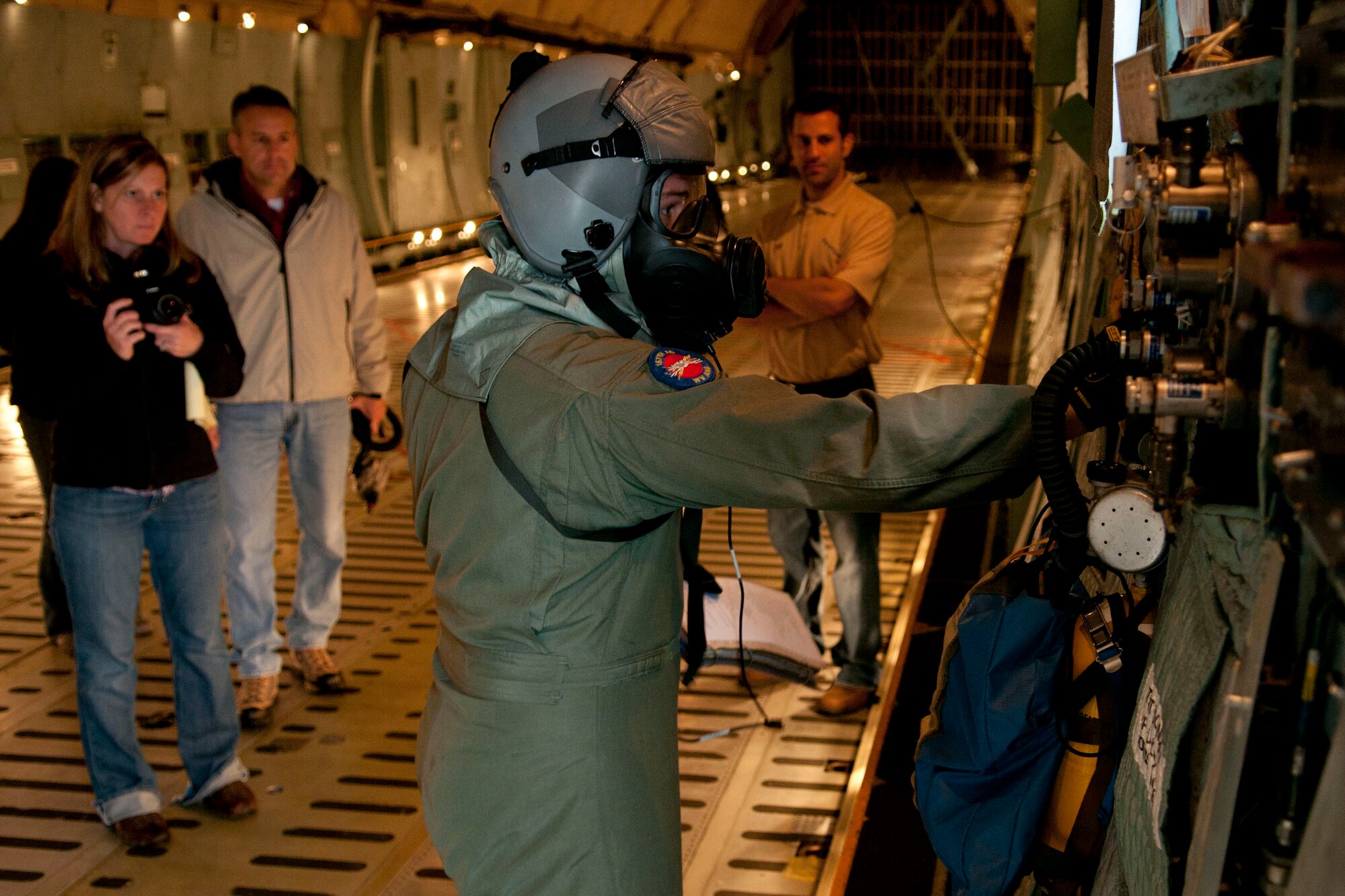 Technical Sgt. Michael Lindamood, a loadmaster for the 167th Airlift Squadron, performs a preflight inspection while wearing a joint service aircrew mask (JSAM), as a research team for the JSAM observes. A Department of Defense research team working on the development of a JSAM conducted field assessments at the 167th Airlift Wing, West Virginia Air National Guard unit in Martinsburg, WV,  December 7, 2011. The team had aircrew in each of the flying positions don the mask and accompanying gear and perform their duties on a C-5 aircraft. (Air National Guard photo by Master Sgt. Emily Beightol-Deyerle)