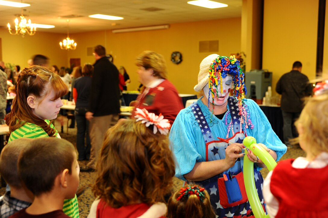 Holly Kennedy from the Central States Fair Office in Rapid City, S.D., entertains children by blowing balloon animals during the breakfast with Santa event at the Dakota’s Club on Ellsworth Air Force Base, S.D., Dec. 3, 2011. The breakfast invited Airmen and their families to eat with Santa while enjoying entertainment such as arts and crafts, face-painting and pictures with Santa. (U.S. Air Force photo by Airman 1st Class Zachary Hada/Released)