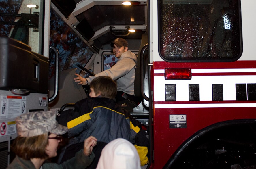 Master Sgt. Susan McGarry, 139th Operations Support Flight deputy airfield manager, helps kids get inside a Missouri Air National Guard fire truck at the Noyes Home for Children in St. Joseph, Mo., Dec. 13, 2011. Guardmembers of the 139th Airlift Wing teamed up local businesses to donate Christmas gifts for the Noyes Home. (Missouri Air National Guard photo by Staff Sgt. Michael Crane)