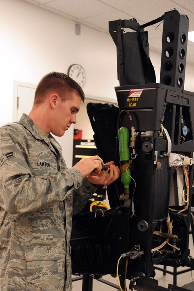 Airman 1st Class Joseph Lawton, 4th Component Maintenance Squadron aircrew egress systems journeyman, removes an oxygen bottle from an ejection seat during a 36-month inspection on Seymour Johnson Air Force Base, N.C., Dec. 12, 2011. There is only one oxygen bottle on each seat and is used only if aircrew eject at over 14,000 feet because they cannot breathe on their own at high altitudes. (U.S. Air Force photo by Senior Airman Whitney Stanfield)