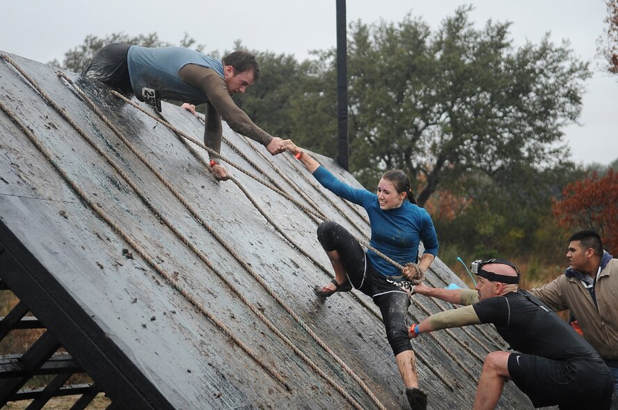 Spartan warriors struggle to climb a slippery wall coated with liquid soap during the Spartan Race sponsored by the Air National Guard at Glen Rose, Texas, Dec. 3, 2011. The wall obstacle is extremely difficult to climb without teamwork and camaraderie. (Air National Guard photo by Senior Master Sgt. Elizabeth Gilbert)