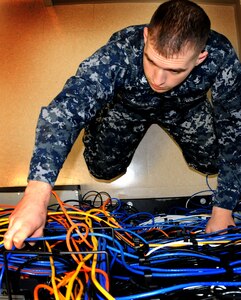 Petty Officer 3rd Class Michael Malidore, an Information Systems Technician at Naval Health Clinic Charleston, patchs a network drop onboard Joint Base Charleston - Weapons Station Dec. 14.  The network drop is a connection that feeds information from the servers to the computers in health care providers’ and staff members’ offices. (U.S. Navy photo/Petty Officer 2nd Class Class Brannon Deugan)