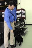 Retired Marine Sgt. Jason Blondin, from Wounded Warrior Battalion East, gives a treat to his newly adopted four-year-old black Labrador Retriever, Eden, which was provided by Carolina Canines for Service and the Naval Consolidated Brig Charleston during a ceremony at NAVCONBRIG, March 31. The partnership of CCFS and NAVCONBRIG provides highly trained service dogs to wounded warriors. (U.S. Navy photo/Petty Officer 3rd Class Brannon Deugan) 

