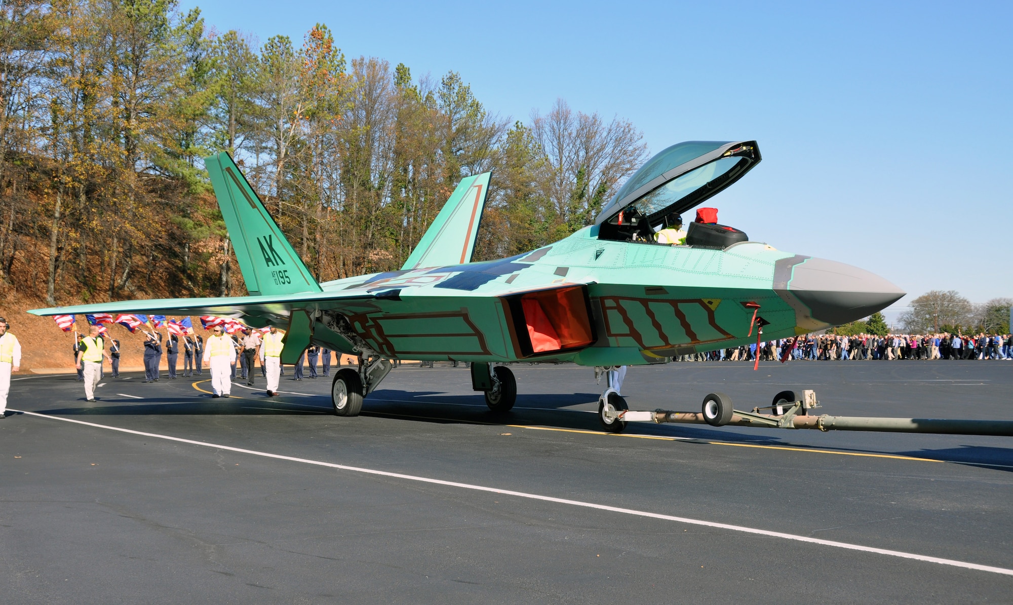 The final F-22 Raptor is led out of the Lockheed Martin assembly line followed by a local marching band, members of the military, hundreds of Lockheed employees and other supporters at the Marietta, Ga. plant Dec. 13. The jet is the last of 187 F-22s produced for the Air Force completing its operational fleet. (U.S. Air Force photo/ Senior Airman Danielle Purnell)