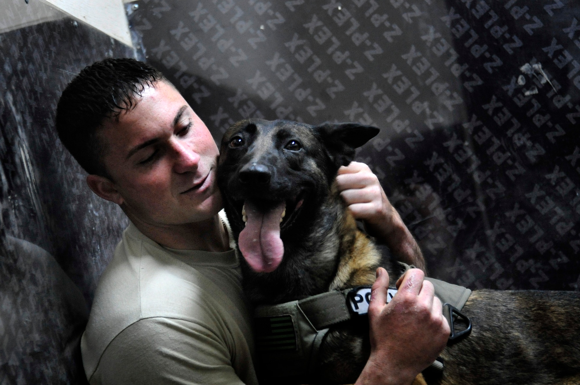 Geri, a patrol and explosive detector dog assigned to the 447th Expeditionary Security Forces Squadron, takes a break from a hard day of training with his handler Senior Airman Stephen Hanks, 447th ESFS military working dog handler, in the kennel of Sather Air Base, Baghdad, Iraq, Dec. 11, 2011. For the last six months Geri and Hanks, have been supporting Operation New Dawn by providing explosive and psychological deterrence. Hanks and Geri are deployed from Patrick Air Force Base, Fla. Hanks is from Amherst, Mass. (U.S. Air Force photo/Master Sgt. Cecilio Ricardo)
