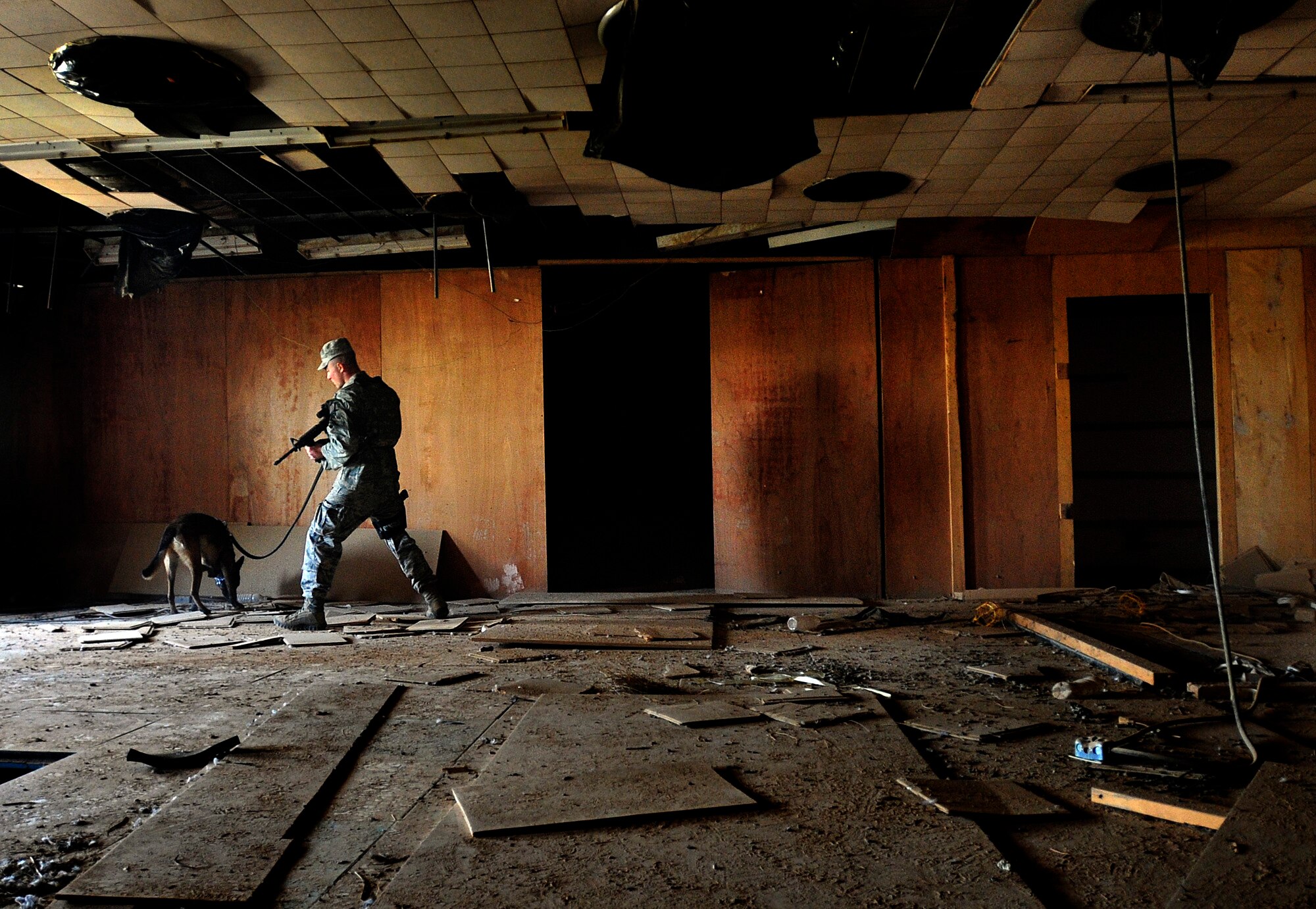 Senior Airman Stephen Hanks, 447th Expeditionary Security Forces Squadron military working dog handler, and Geri, 447th ESFS patrol and explosive detector dog, secure an abandoned building on a routine patrol by checking the location for explosives or squatters on Sather Air Base in Baghdad, Iraq, Dec. 11, 2011. For the last six months Geri and Hanks, have been supporting Operation New Dawn by providing explosive and psychological deterrence. Hanks and Geri are deployed from Patrick Air Force Base, Fla. Hanks is from Amherst, Mass. (U.S. Air Force photo/Master Sgt. Cecilio Ricardo)