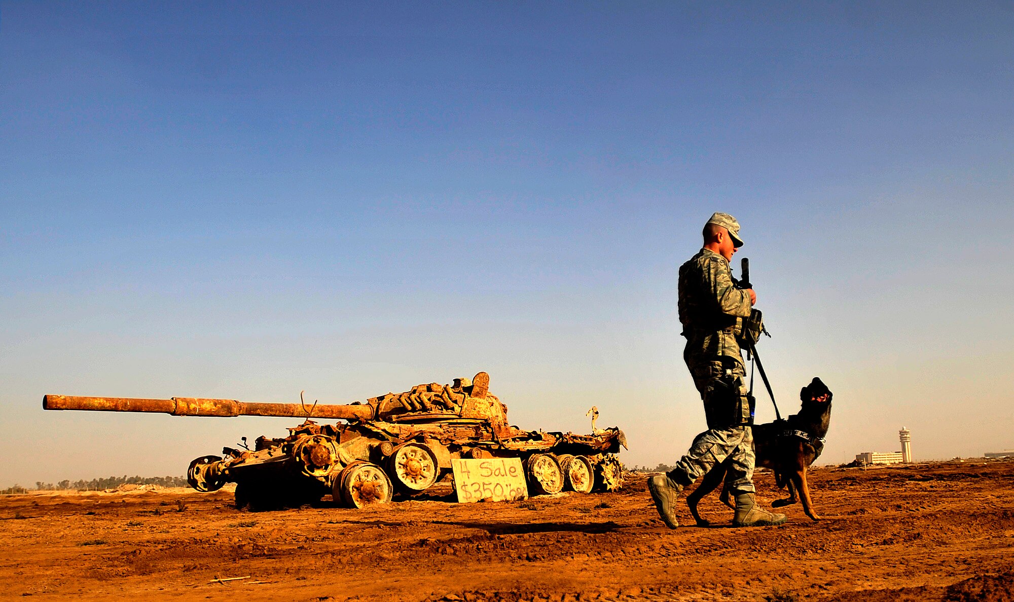 Senior Airman Stephen Hanks, a military working dog handler assigned to the 447th Expeditionary Security Forces Squadron, and Geri, a patrol and explosive detector dog with the 447th ESFS, patrol the perimeter of Sather Air Base in Baghdad, Iraq, Dec. 11, 2011. For the last six months Geri and Hanks, have been supporting Operation New Dawn by providing explosive and psychological deterrence. Hanks and Geri are deployed from Patrick Air Force Base, Fla. Hanks is from Amherst, Mass. (U.S. Air Force photo/Master Sgt. Cecilio Ricardo)
