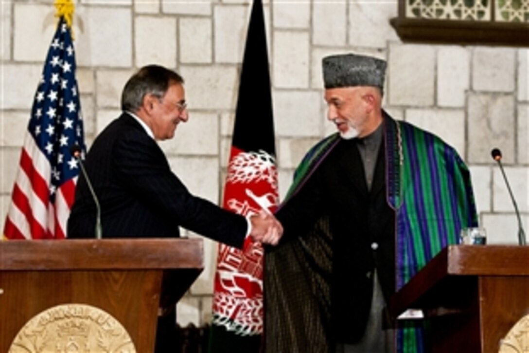 U.S. Defense Secretary Leon E. Panetta shakes hands with Afghan President Hamid Karzai at a press conference in Kabul, Afghanistan, Dec. 14, 2011. Panetta said the United States was committed to working with the Afghan government to promote a free and independent country.