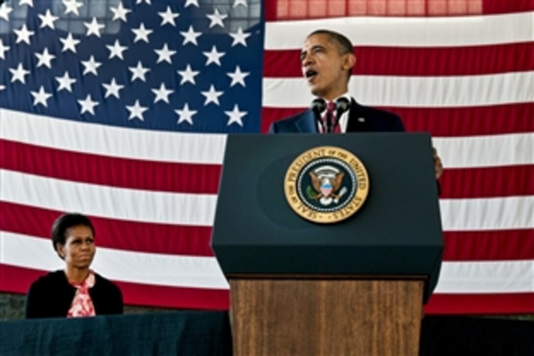 President Barack Obama speaks to troops on Fort Bragg, N.C., Dec. 14, thanking them for their service during Operation Iraqi Freedom and Operation New Dawn as the Iraq war comes to an end. First Lady Michelle Obama listens to his speech.