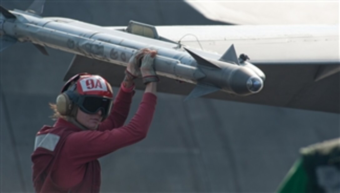 Airman Tiffany Wilchek arms ordnance on an F/A-18C Hornet assigned to Strike Fighter Squadron 97 on the flight deck of the aircraft carrier USS John C. Stennis (CVN 74) in the Arabian Gulf on Dec. 10, 2011.  The John C. Stennis is deployed to the U.S. 5th Fleet area of responsibility conducting maritime security operations and support missions as part of Operations Enduring Freedom and New Dawn.  