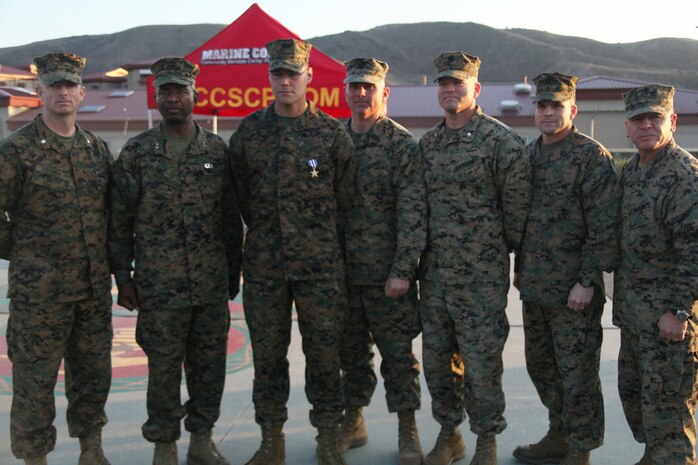 Lance Cpl. Cody Goebel, 2nd Battalion, 5th Marine Regiment, poses with Maj. Gen. Ronald Bailey, commanding general, 1st Marine Division, and other members of his higher command after his Silver Star award ceremony, Dec. 14, 2011. Goebel was awarded the Silver Star for actions while he was in Afghanistan with 3rd Battalion, 5th Marine Regiment.  Goebel was shot in the neck while on post in Helmand Province, Afghanistan. Ignoring his wound, he returned fire and refused medical attention until he was properly relieved.