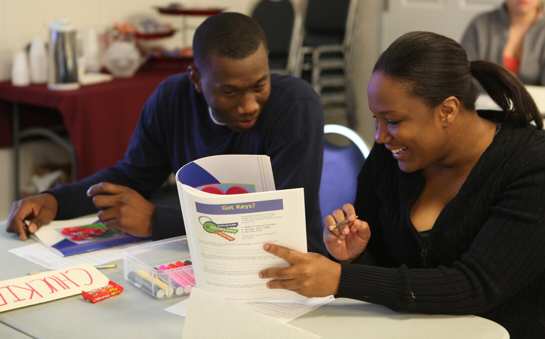 A couple look over their workbooks during Marine Corps Community Service’s Marine Corps Family Team Building Marriage Enrichment Workshop at Midway Park, a Marine Corps Base Camp Lejeune housing area, Dec. 16. Through the workshop they spent the time learning techniques and gaining a better understanding of the ways relationships work. ::r::::n::::r::::n::