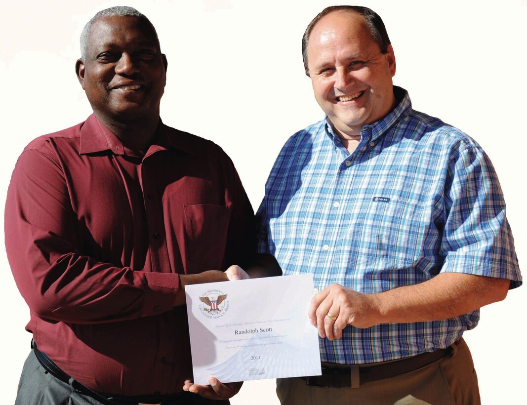 Michael Carroll, right, systems analyst, Marine Corps Systems Command, congratulates Randy Scott, project manager, MCSC, on his third consecutive President’s Volunteer Service Award, recently. Scott has volunteered with the Albany Young Marines Program for eight years.