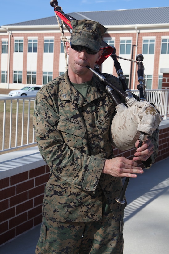 Sgt. Mark A. Matice plays his bagpipes in front of the headquarters building, Dec. 15. Matice has been playing since 2007 in both Iraq and Afghanistan. He plays the pipes because, according to him, they bring people together for a fun time. A head injury left him unable to play the pipes as often as he would like because playing now gives him migraines, but Matice hopes his injuries will heal and allow him to play often again.