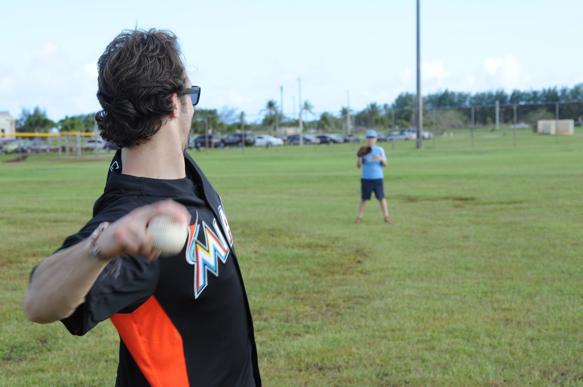 ANDERSEN AIR FORCE BASE, Guam-- Bryan Peterson an outfielder from the Miami Marlins Major League Baseball Team, plays catch with an Team Andersen youth during the baseball clinic they held here, Dec.9. The team held the clinic with more than 15 kids, playing a quick game. (U.S. Air Force photo/Senior Airman Carlin Leslie)
