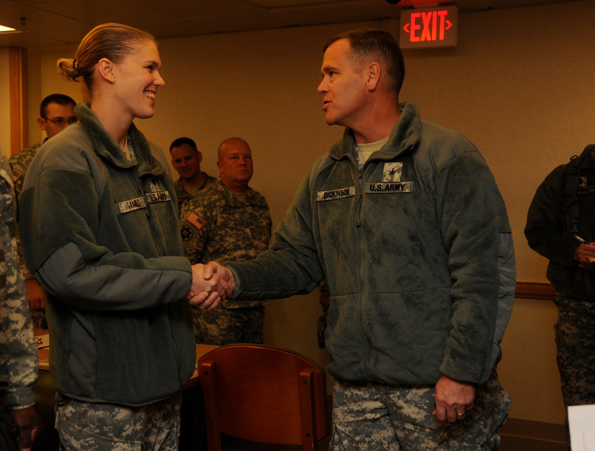 U.S. Army Brig. Gen. James Dickinson, 94th Army Air and Missile Defense commander, presents his coin to Spc. Tabitha Gamble, Alpha Battery 2-1 Air Defense Artillery orderly room clerk, at Kunsan Air Base, Republic of Korea, Dec. 8, 2011. Dickinson visited Soldiers and facilities of the Alpha Battery, 2nd Battalion of the 1st Air Defense Artillery during his tour of the Wolf Pack. (U.S. Air Force photo by Staff Sgt. Rasheen Douglas/Released