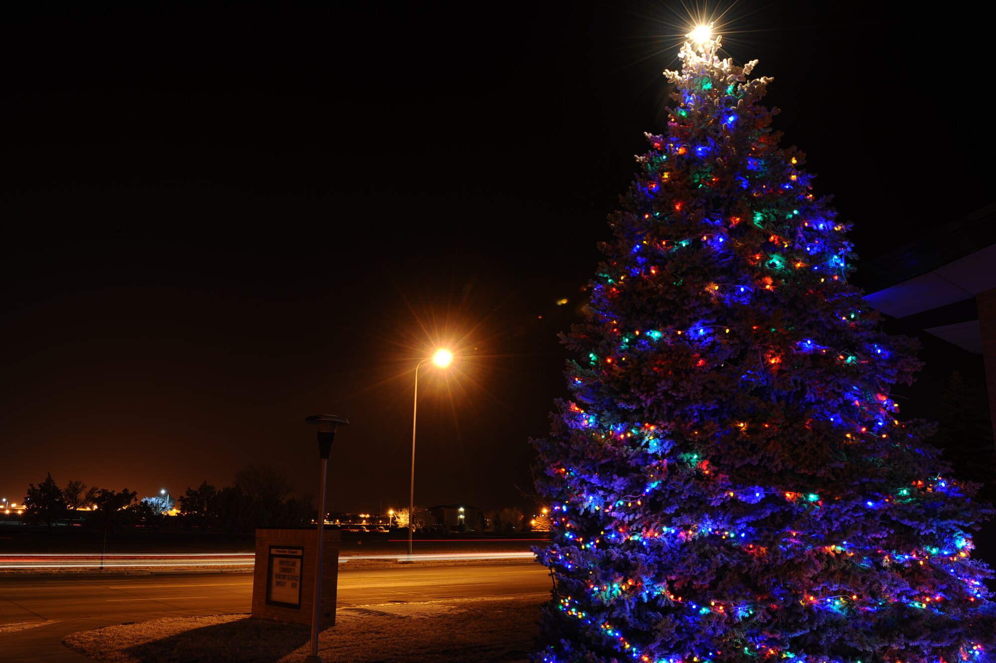 The base Christmas tree shines brightly next to the Freedom Chapel on Ellsworth Air Force Base, S.D., Dec. 13, 2011. The trees lights will shine throughout the holiday season and bring festive cheer to the Ellsworth community. (U.S. Air Force photo by Airman 1st Class Zachary Hada/Released)