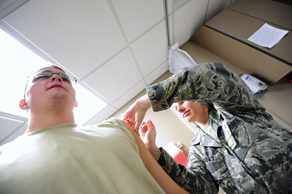 Staff Sgt. Kristy Bussey, 92nd Medical Operations Squadron immunizations technician, administers a flu shot to a patient Dec 9.  (U.S. Air Force photo/Airman 1st Class Taylor Curry)