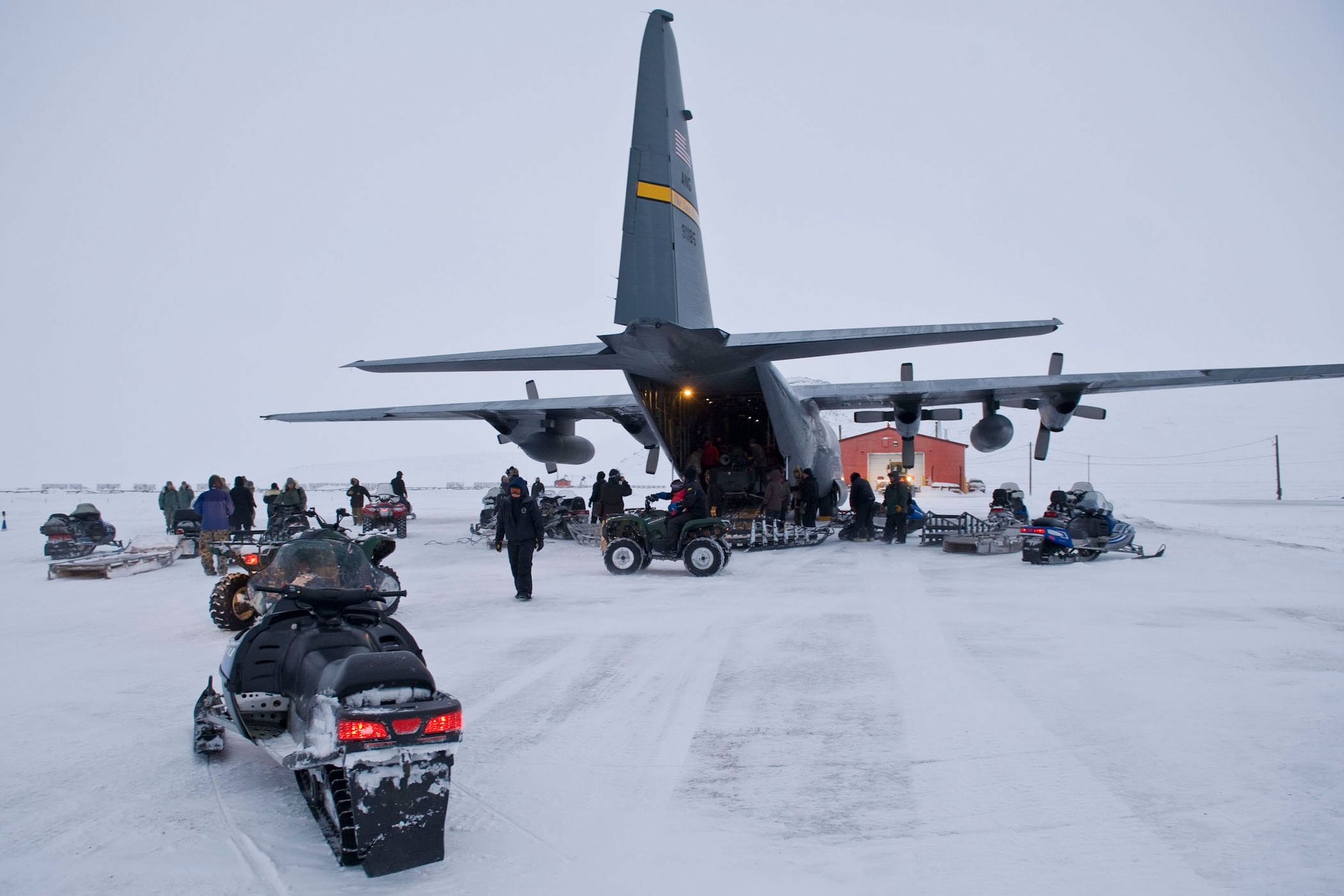 A C-130 from the Alaska Air National Guard's 144th Airlift Squadron is unloaded on the airstrip of Wales, Alaska, Dec. 9. The aircraft along with about 35 volunteers from Anchorage were in Wales for an Operation Santa Claus mission. Op Santa has been a tradition for the Alaska National Guard since 1956. Each year, it brings Santa, Mrs. Claus, along with gifts to some of the small, remote villages of Alaska. (National Guard photo/MSgt. Shannon Oleson)
