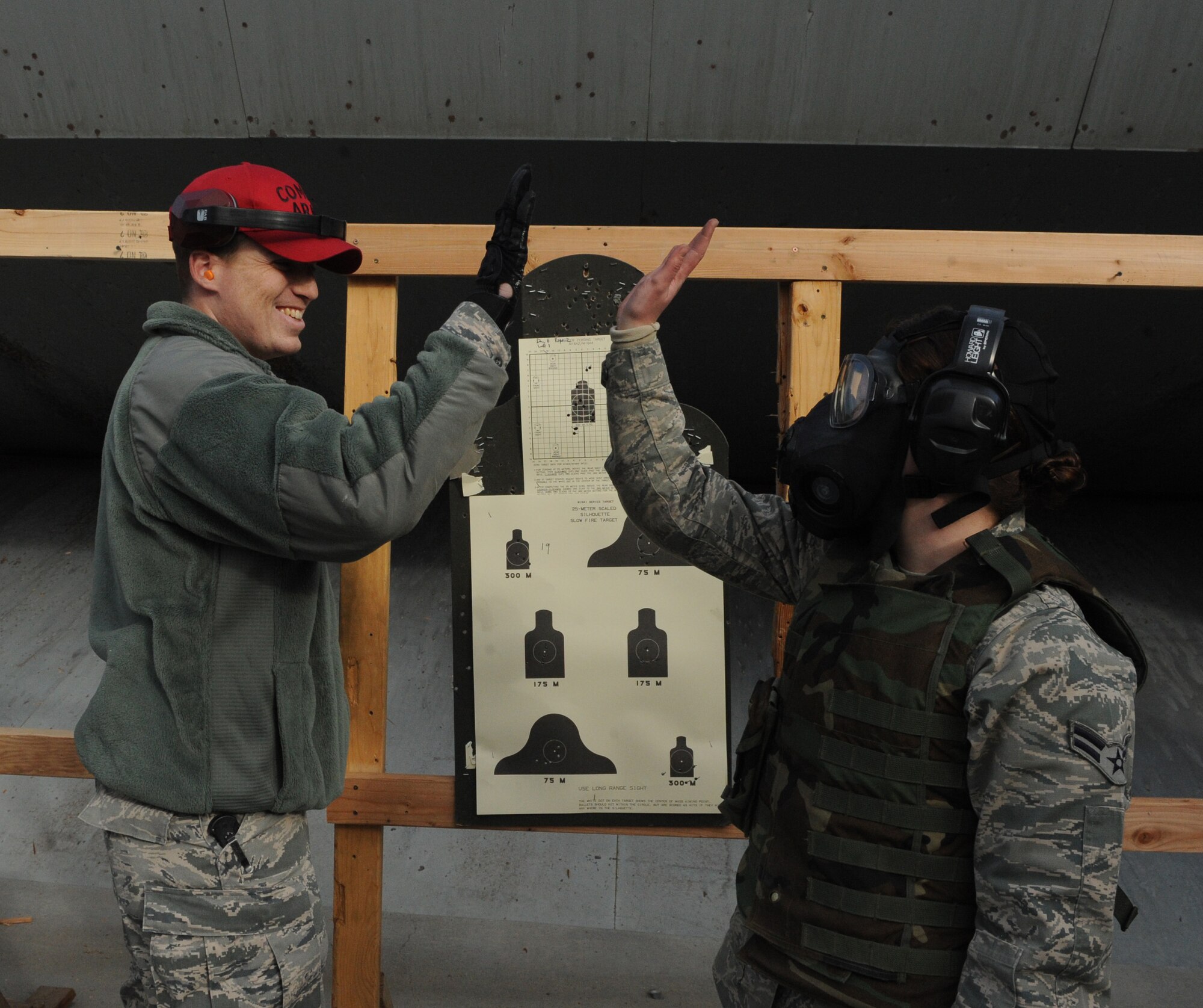 Senior Airman William Rhodes, 366th Security Forces Squadron combat arms instructor, congratulates an Airman for hitting her mark during the new Air Force Rifle Qualification Course Dec. 14, 2011, at Mountain Home Air Force Base. The revamped course was implemented here Nov. 1, and more than 400 Gunfighters have attended the new training. (U.S. Air Force photo/Senior Airman Alyssa C. Wallace)