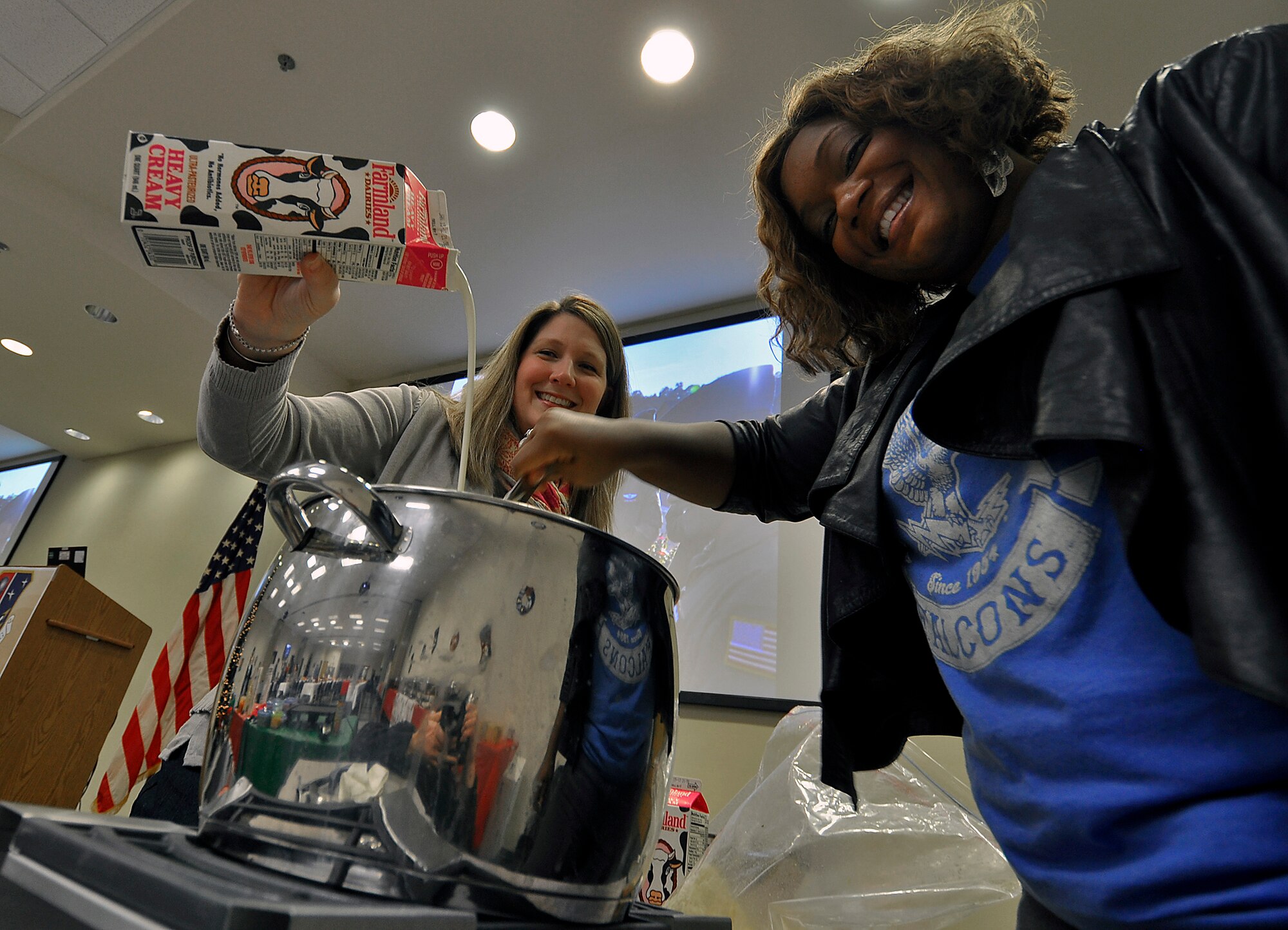 The Food Network's Sunny Anderson (right) and Master Sgt. Megan Parrot, 514th Aircraft Maintenance Squadron, make grits for the 23rd Annual Holiday Breakfast hosted by Chief Master Sgt. Antoinette Kolesnikov, 514th Force Support Squadron. Anderson previously served as a broadcaster in the Air Force. (U.S. Air Force photo by Shawn J. Jones)