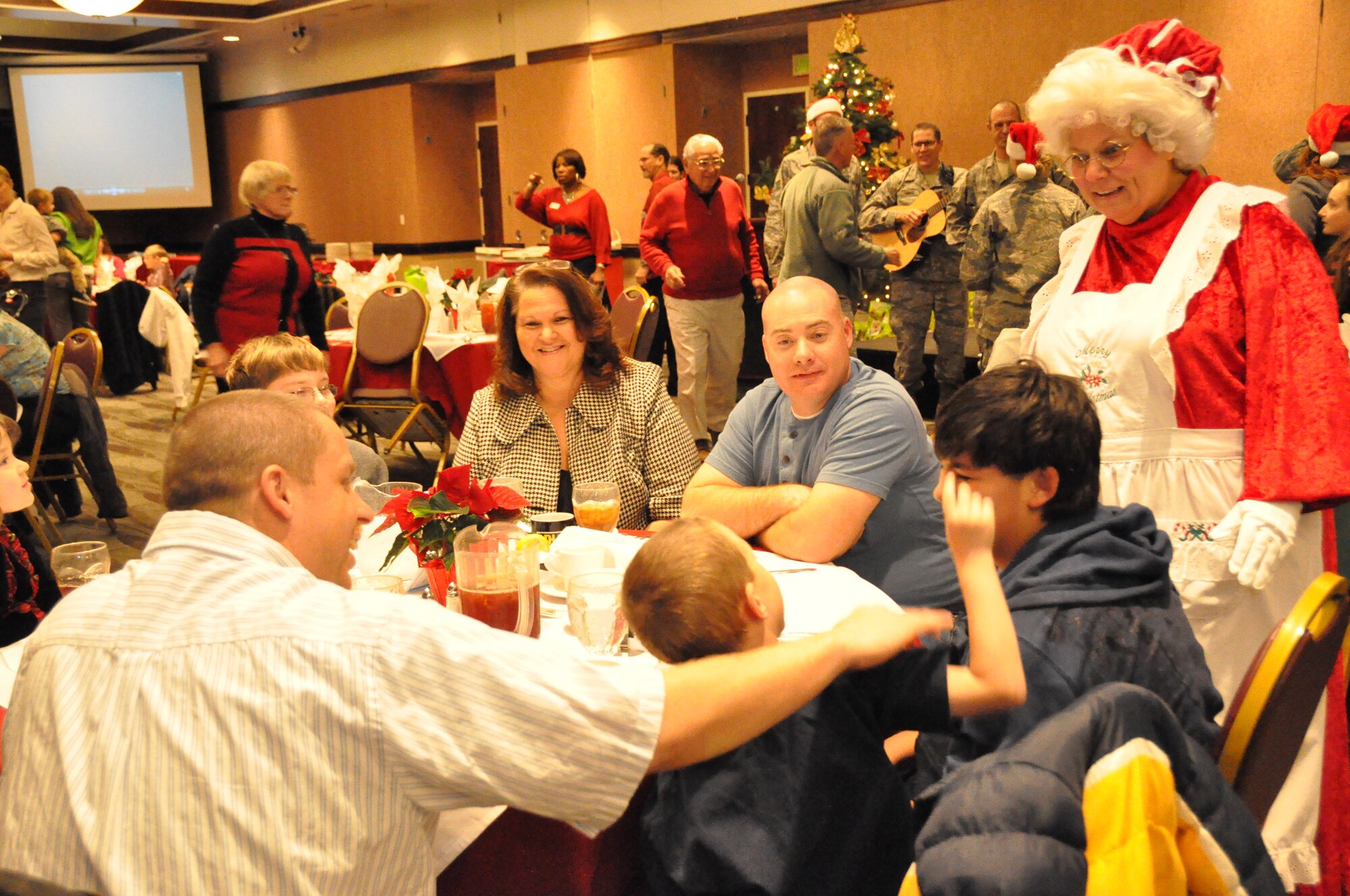 Mrs. Claus makes her way around the tables during the Special Needs holiday party Tuesday and interacts with the children. (U.S. Air Force photo/Airman 1st Class Madelyn Ottem)