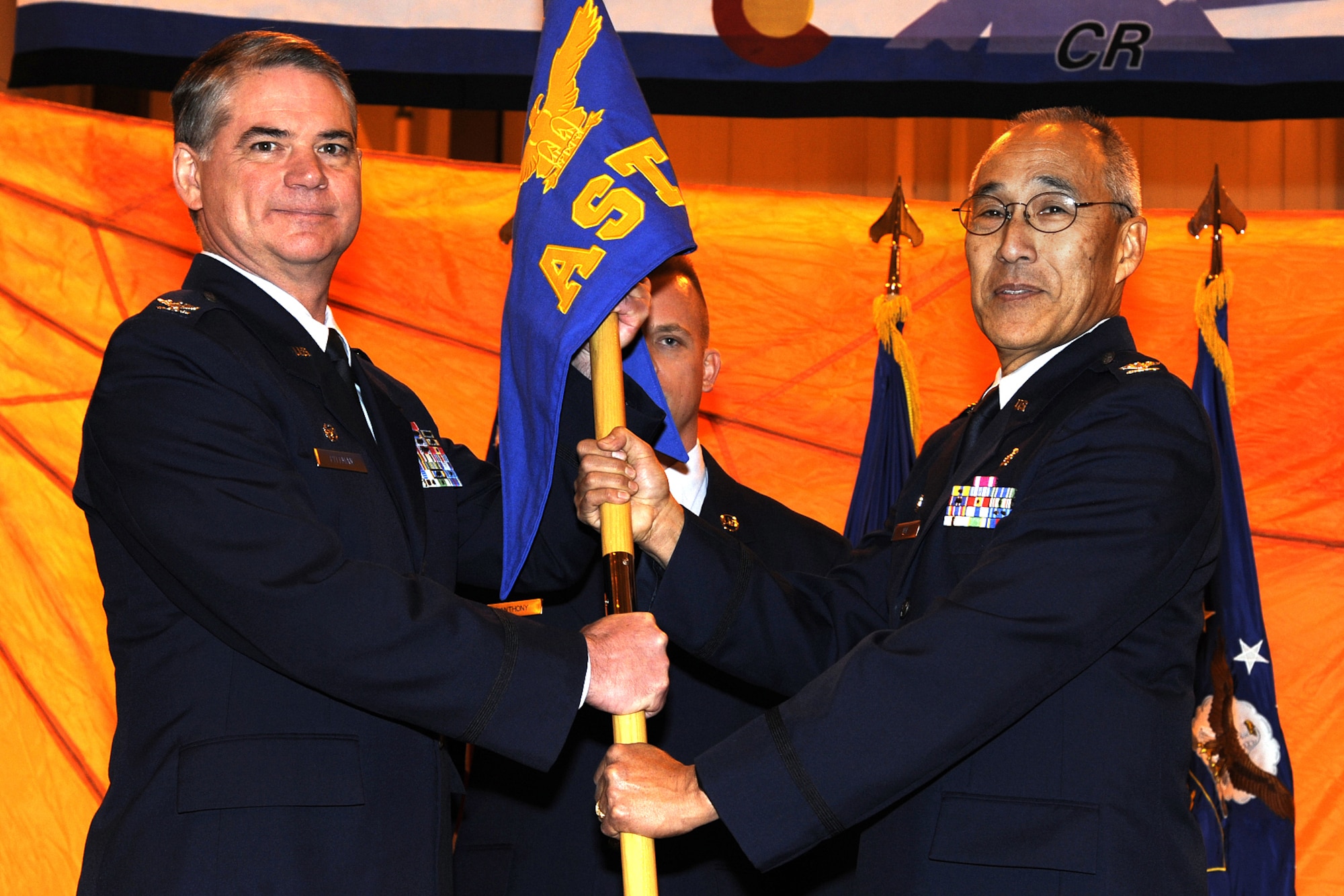 302nd Airlift Wing Commander, Col. Jay Pittman (on left) accepts the 302nd Aeromedical Staging Squadron's guidon from outgoing commander Col. Sheldon Omi during a change of command ceremony held during the Wing's December UTA. Colonel Omi is retiring after nearly three decades of esteemed military service. Former 302nd Aeromedical Evacuation Squadron Commander Col. Kathleen Flarity (not pictured) will replace Col. Omi as commander of the 302nd ASTS. (U.S. Air Force photo/Robbie Bussard)