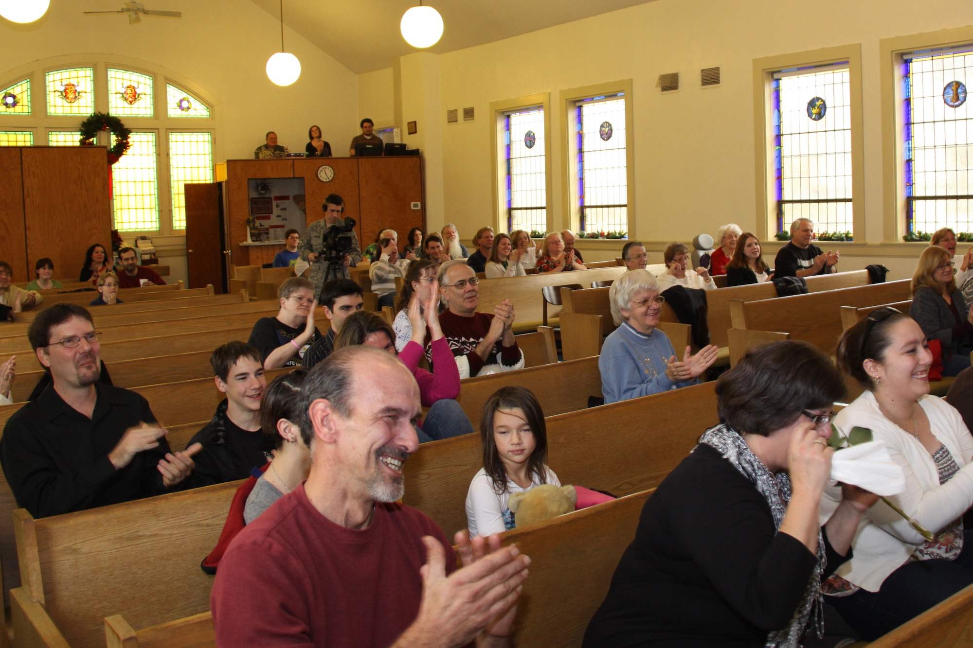 The Emmanuel Christian Church congregation applauds for the early return of its associate minister, Capt. Thomas Fodi, Dec. 4. The congregation was pleasantly surprised when the captain entered the sanctuary of the church four weeks prior to his scheduled arrival home from Iraq. (U.S. Air Force photo by Senior Airman Jonathan Hehnly/released)