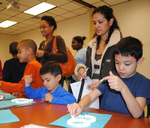 Pablo Rosa (left), 4, and his brother, Jesus Rosa, 6, make snow men with marshmallows as their mother, Lisandra Rosa, looks on. (Photo by Toni Guagenti)